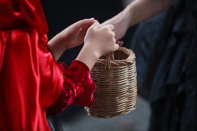 Midsection of child holding basket doing trick or treat