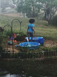 Boy sitting on grass against trees