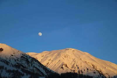 Scenic view of snowcapped mountains against clear blue sky