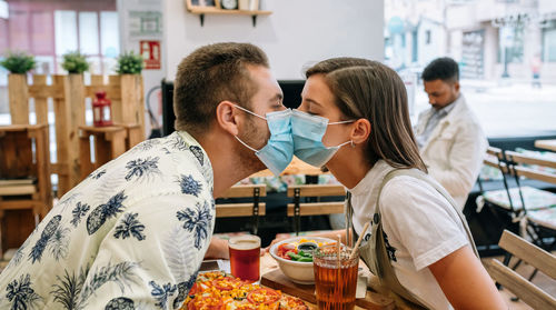 Rear view of man and woman at restaurant table