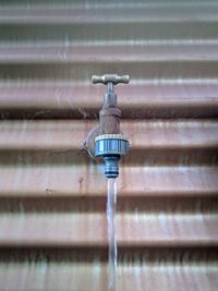 Close-up of water drops on metal against wall