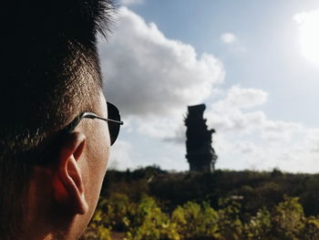 Close-up of young man wearing sunglasses against sky