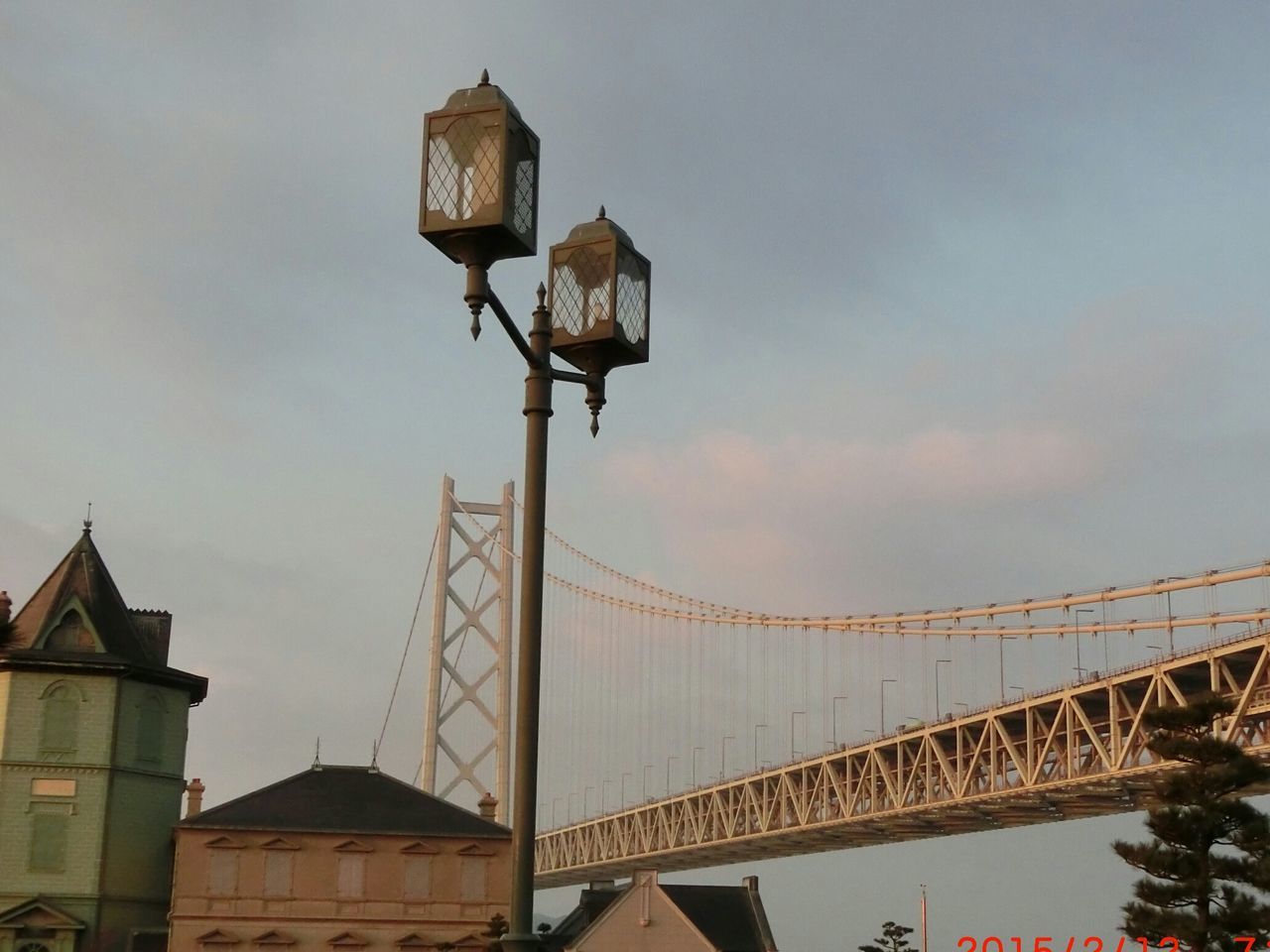 architecture, built structure, building exterior, low angle view, sky, street light, lighting equipment, cloud - sky, outdoors, connection, high section, house, roof, no people, railing, building, cloud, lantern, dusk, cloudy