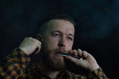 Close-up of man holding equipment in mouth