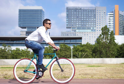 Full length of man riding bicycle on street