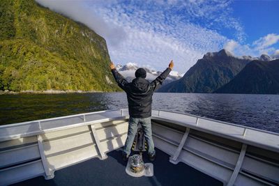 Rear view of man photographing lake