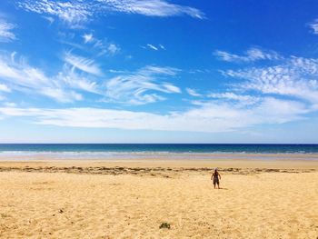 Rear view of person against scenic view of beach