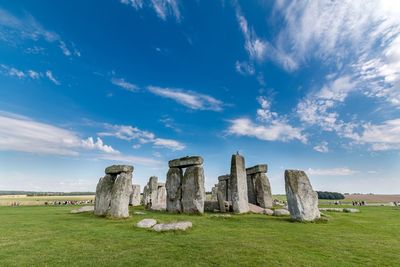 Stonehenge on grassy field against sky