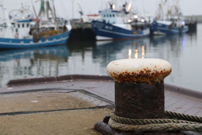 Close-up of rope tied to bollard on pier