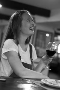 Close-up of a smiling young woman holding drink