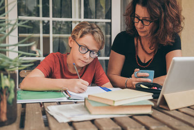 Mother assisting son in homework at home