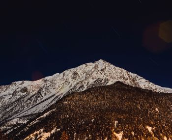 Low angle view of snow covered mountains against clear sky