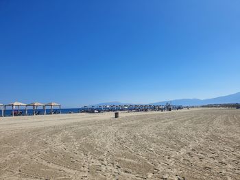 Scenic view of beach against clear blue sky