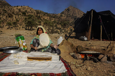 Portrait of woman sitting on barbecue grill