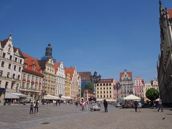 Group of people in town against buildings in city