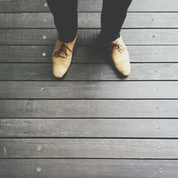 Low section of woman standing on wooden floor