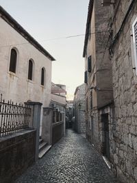 Narrow alley amidst buildings against sky