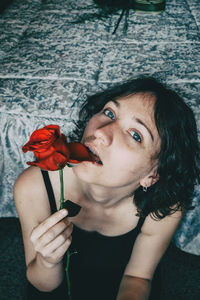 Close-up portrait of woman holding red flower