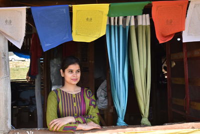 Portrait of smiling young woman standing at store