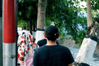 Rear view of man standing against trees