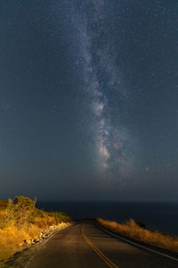 Empty road against sky at night