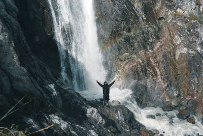 Rear view of man standing on rock