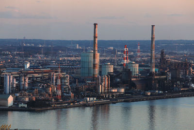 River by city against sky during sunset