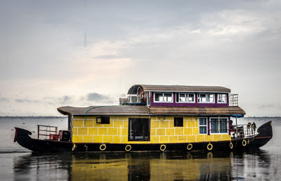 Yellow ship in sea against sky