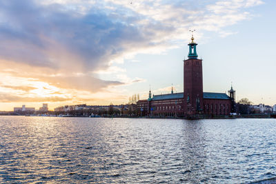 Kungsholmen town hall in city by riddarfjarden during sunset