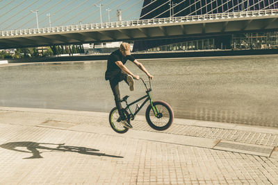 Man riding bicycle on bridge