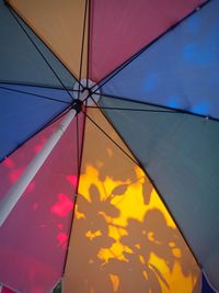 Low angle view of yellow umbrella against blue sky