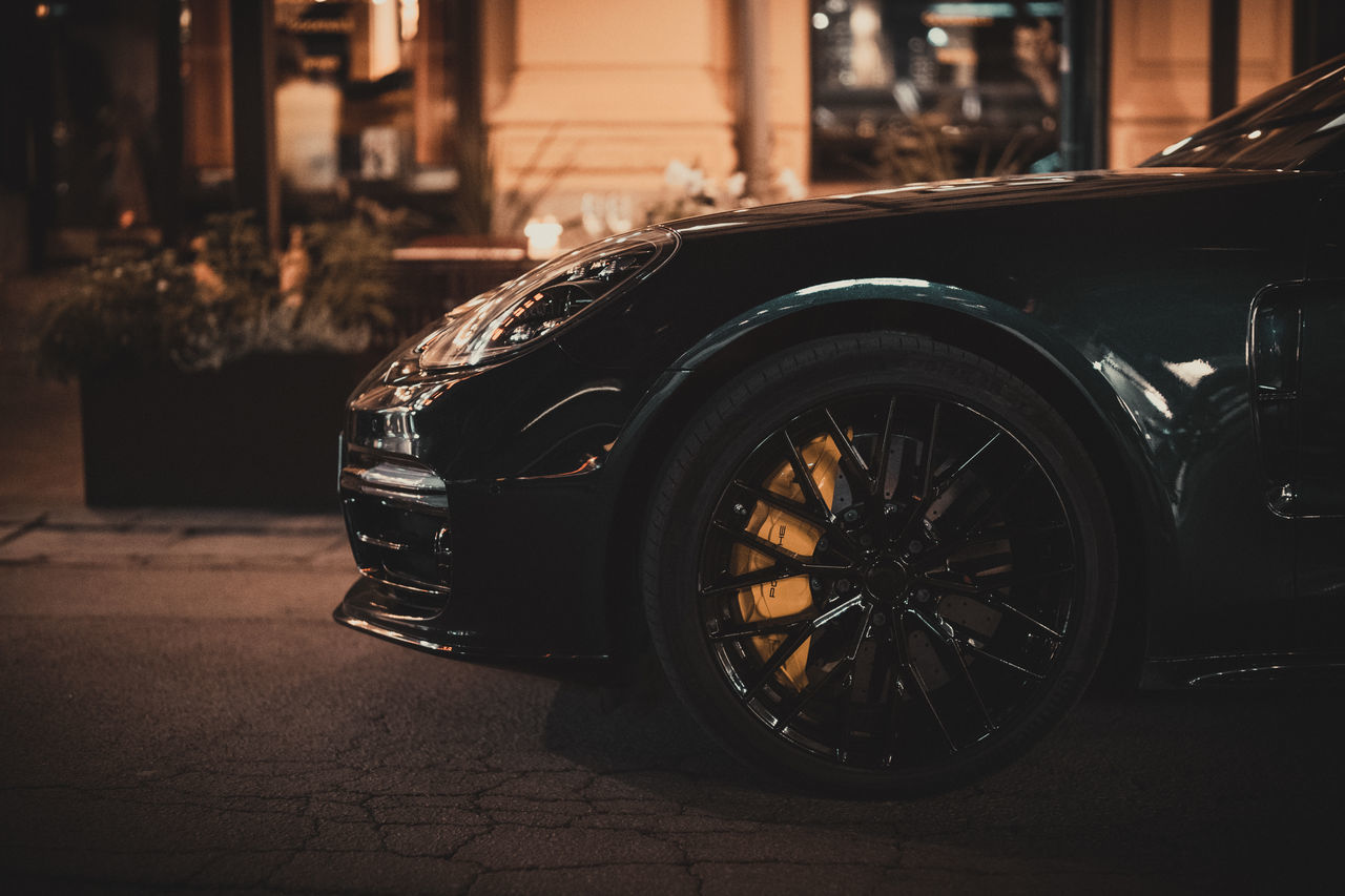 car, mode of transportation, transportation, vehicle, motor vehicle, automobile, land vehicle, supercar, city, sports car, street, architecture, wheel, luxury vehicle, retro styled, building exterior, focus on foreground, night, tire, no people, built structure, camera, outdoors