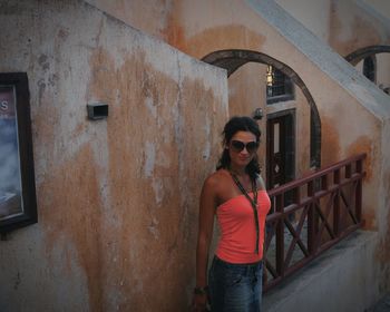 Portrait of young man standing by railing