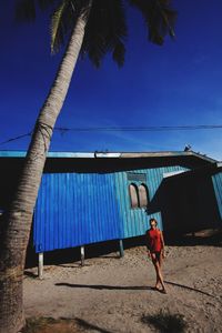 Low angle view of woman standing against clear sky
