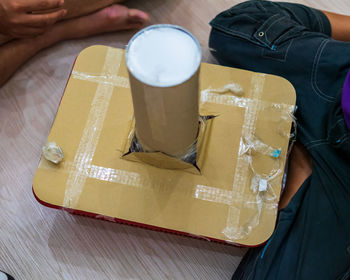 High angle view of man holding coffee cup on table