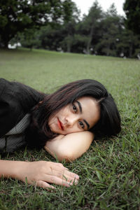 Portrait of young woman lying down on land