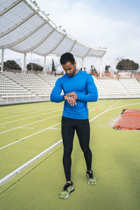 Male athlete checking time on watch