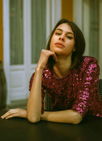 Portrait of young woman sitting at home