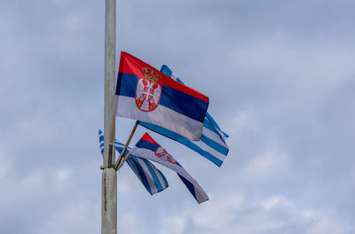 Low angle view of flag flags against sky