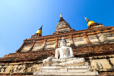 Low angle view of statue against building against sky