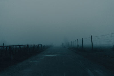 Scenic view of road against sky during foggy weather