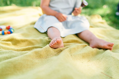 Low section of baby relaxing on bed at home