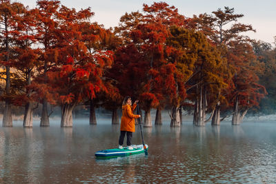 Rear view of woman kayaking in lake