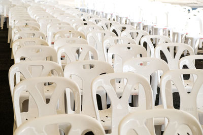 White chairs arranged in row at auditorium