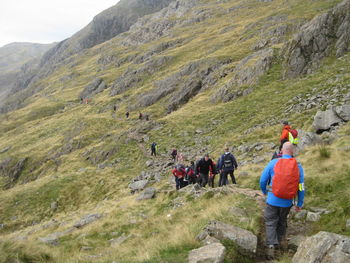 Rear view of people walking on mountain