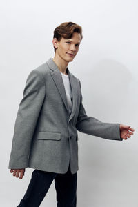 Portrait of young man standing against white background