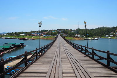 Footbridge over river against sky