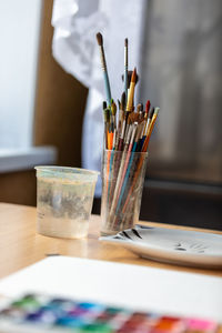Art brushes for painting in a glass cup on the desktop.