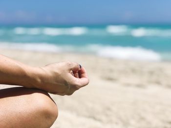 Midsection of man hand on sea shore