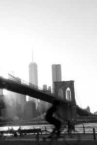 Bridge in city against clear sky